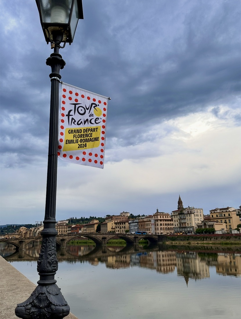 A Tour de France banner on a lamppost beside the Arno in Florence